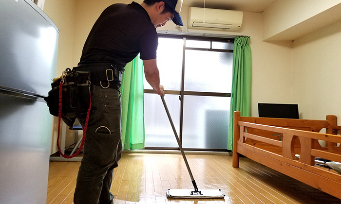 床を掃除する男性